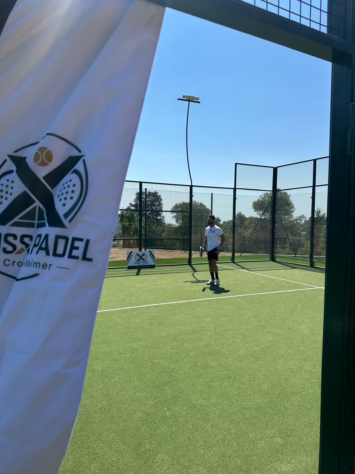 Joueur seul sur le court de padel derrière l'oriflamme Cross Padel