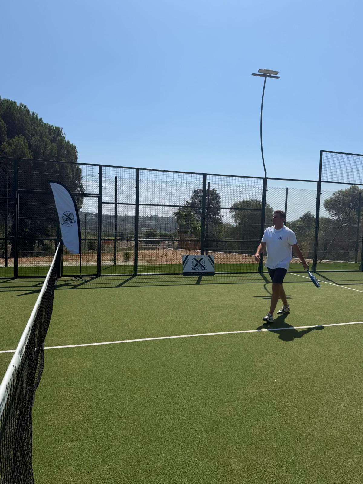 Joueur Cross Padel au service sur le court de padel